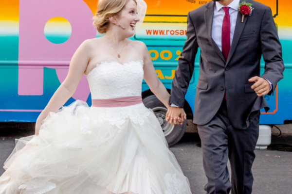 Newlyweds running in front of a food-truck at Sanctuary Event Space